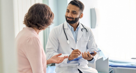 Cardiologist explaining an aortic heart valve model to a patient during a consultation